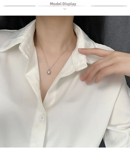 Close-up of pearl pendant necklace on model with French vintage silk shirt detail