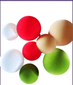 Detail of multi-colored flocked Christmas balls in red, green, and white on a clean background