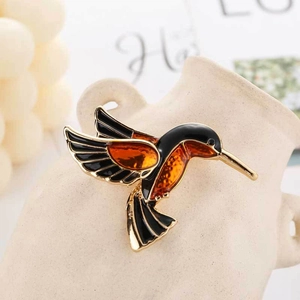 Exquisite hummingbird brooch with orange enamel and gold metal wings detail view