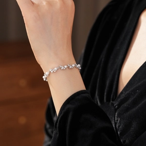 Close-up of pearl and zircon bracelet on wrist featuring elegant French vintage style