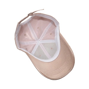Detailed interior of champagne satin baseball cap with metal buckle and soft silk texture
