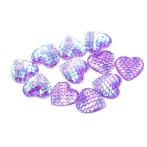 Purple heart-shaped resin cabochons with iridescent fish scale texture on white surface