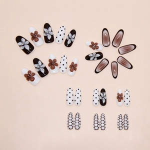 Detail of almond nails featuring 3D embossed lilies and vintage brown gradient textures