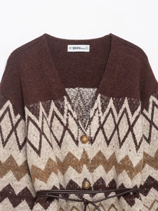 Detailed view of knit cardigan with geometric jacquard pattern, V-neck, buttons and belt