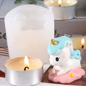 Detailed view of unicorn candle mold and finished wax statue on a cozy desk setup
