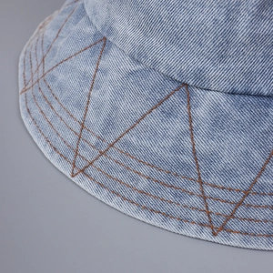 Minimalist denim bucket hat with decorative orange geometric stitching on the brim