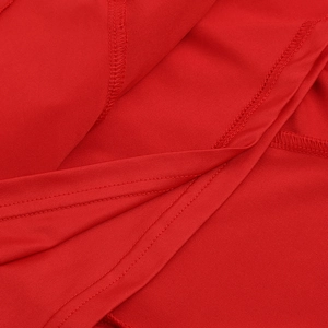 Macro detail of red ruffle dress showing high-quality stitching and fabric texture