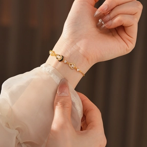 Macro detail of gold plated heart bracelet with white pearls and sparkling zircons