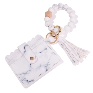 Detail of white marble pattern card holder with silicone bead wristlet and PU tassel