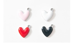 Close-up of four colorful 3D heart-shaped alloy pendants for DIY jewelry making
