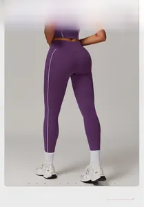 Detalle de los leggings de yoga morados de cintura alta con raya blanca en el lateral