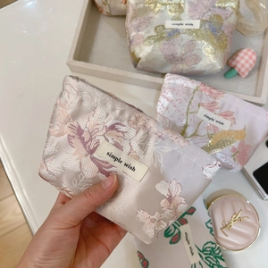 Detailed texture of jacquard fabric mini bag with floral embroidery and white label
