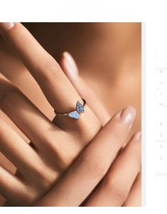 Close-up of s925 silver butterfly ring featuring light blue crystals on model's hand