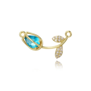 Detailed view of gold tulip charm with blue gemstone and pavé crystal leaves