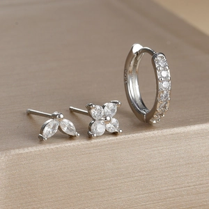 Macro shot of S925 silver earrings set with zircon petals and engraved hallmark