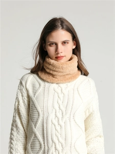 Detail of soft camel coral fleece neck warmer worn with a white cable knit sweater