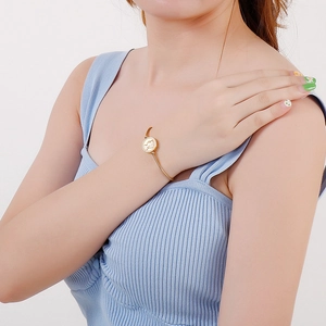 Detailed view of an adjustable gold coin bracelet on a female wrist for a stylish look