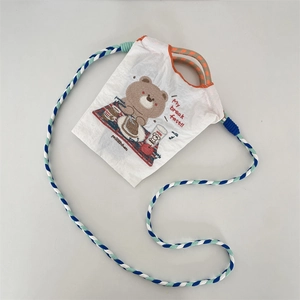 Détail de la broderie d'ours et de la bandoulière tressée du mini sac en toile blanc