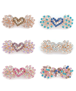 Dettaglio di fermagli per capelli a cuore con ali e strass colorati su base in oro