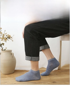 Close-up of light blue combed cotton no-show socks on model with high breathability