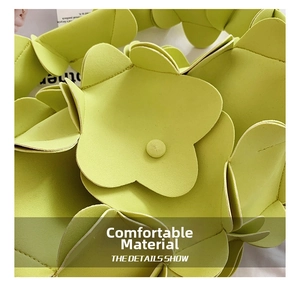 Detailed view of 3D layered flower petals and fine stitching on a green PU leather bag