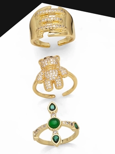 Three gold rings featuring bear, cross, and zircon pave designs on white background
