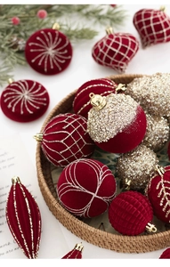 Détail de boules de Noël en velours rouge avec paillettes dorées dans un panier tressé