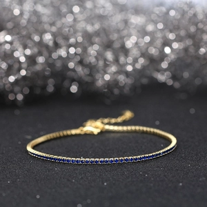 Macro view of gold S925 sterling silver tennis bracelet with deep blue zircon stones