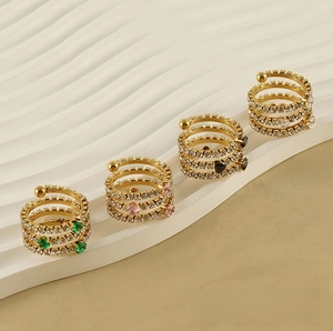 Macro shot of multi-layer spiral gold rings with heart-shaped colorful zircon stones