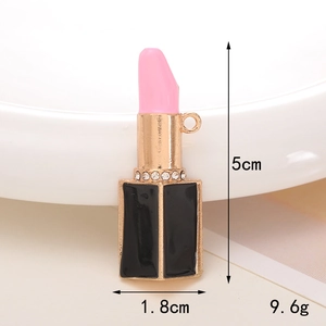 Detail of a lipstick pendant with black enamel finish, gold metal ring, and pink crystal accents