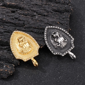 Macro shot of gold and silver lion head shield pendants with rhinestone borders