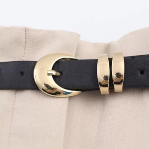 Close-up of black leather belt with golden crescent buckle and double metal rings