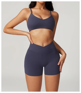 Detail of high-waisted yoga shorts with V-waist design and racerback sports bra in grey-blue