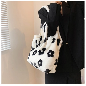 Detail of soft plush floral tote bag showing black flower patterns on white furry fabric
