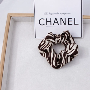 Détail du chouchou en tissu imprimé zèbre marron sur un plateau d'exposition