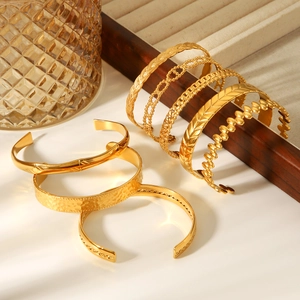 Détail d'un ensemble de bracelets joncs en acier inoxydable plaqué or 18 carats
