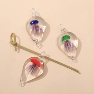 Macro shot of glass water drop pendants featuring detailed jellyfish patterns in three colors