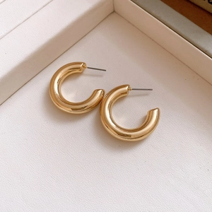 Polished chunky gold C-shaped hoop earrings with high-gloss finish and round silhouette
