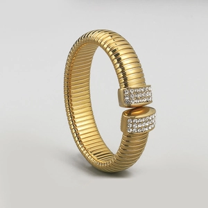 Detailed macro view of gold-plated textured bangle with sparkling crystal end accents