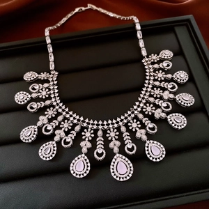 Detailed view of silver necklace with pink teardrop crystal on black leather display