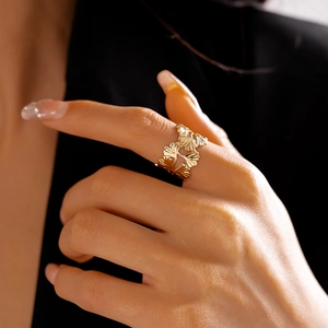 Détail macro d'une bague feuilles de ginkgo dorées avec texture sur la main d'une femme