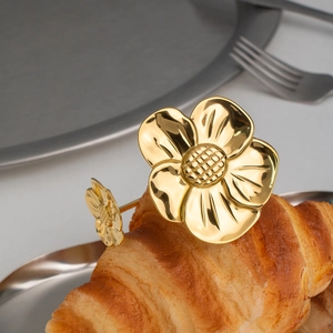 Dettaglio del bracciale aperto a fiore placcato oro 18K su sfondo di croissant