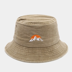 Detail of sunrise embroidery on a washed cotton khaki bucket hat with metal eyelets