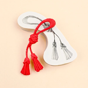 Moule en silicone pour nœuds de glands avec échantillon d'argile rouge sur fond uni