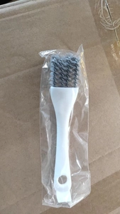 Detailed macro view of a multifunctional kitchen cleaning brush with grey bristles