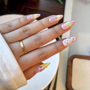 Detail of almond-shaped nails with 3D floral accents and sparkling rhinestones