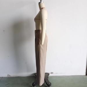 Detail view of brown straight-leg trousers in cotton linen blend on a mannequin