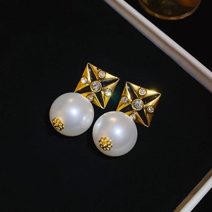 Detail of vintage square gold stud earrings with black enamel, zircon, and large pearl