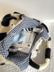 Spacious interior of plush cow print tote bag showing storage for umbrella and books