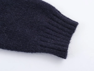 Close-up of navy blue knit sweater sleeve with ribbed cuffs and fuzzy wool texture